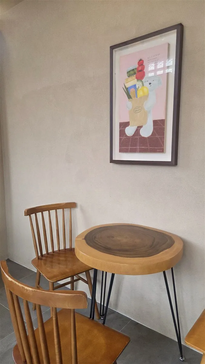 김녕빵집 그림 액자 아래 원목 테이블